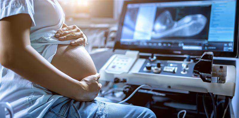 pregnant-woman-sits-front-monitor-with-words-baby-it